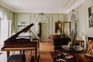 比亚里茨Château du Clair de Lune - Teritoria的一间钢琴客房和一间客厅