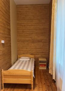 VõhmaVõhma Külamaja的一间小卧室,配有一张床和木墙