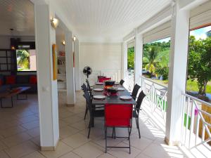 拉特里尼泰Villa Grenadille的阳台的用餐室配有桌椅