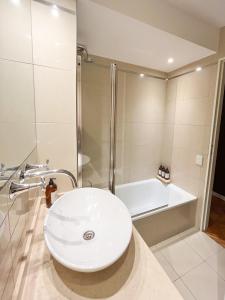 布宜诺斯艾利斯Coqueto departamento en Recoleta的浴室配有白色水槽和淋浴。