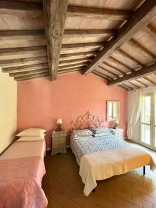 Casa PadulettoVillino Il Paduletto的一间卧室设有两张床,墙壁粉红色