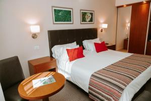耶尔瓦布埃纳Howard Johnson Hotel Yerba Buena的酒店客房设有一张大床和一张桌子。