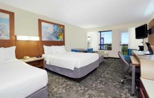 可可比奇Courtyard by Marriott Cocoa Beach Cape Canaveral的酒店客房配有两张床和一张书桌