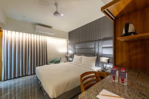 艾哈迈达巴德那兰陀酒店的酒店客房配有一张床铺和一张桌子。