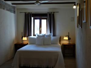 Coscojuela de SobrarbeHotel Posada Al Vent - Adults Only的一间卧室配有一张带白色床单的床和一扇窗户。