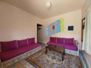 TaghzouteCaiat Lounge Refuge的客厅配有紫色沙发和桌子