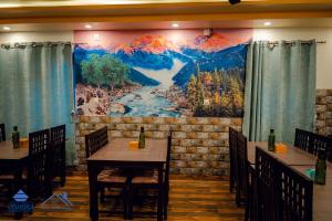 拜拉哈瓦Hotel Happy Home的一间设有桌子的用餐室和墙上的大画