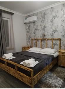 AreniLiViTi的一间卧室配有木床和2条毛巾