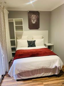 KroondalTen Flags Theme Park的卧室配有一张带狮子照片的床铺。