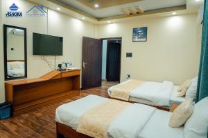 拜拉哈瓦Hotel Happy Home的酒店客房设有两张床和一台平面电视。