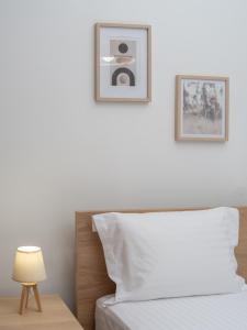 海若克利欧Korai City Vibes的卧室配有一张床,墙上挂有两张照片