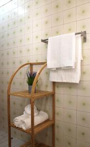 阿尔布费拉Casa do Limoeiro的浴室提供毛巾架和带毛巾的架子。