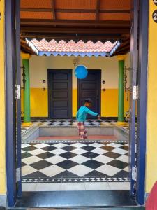 马哈巴利普拉姆Marutham Village Resort的一名男孩在建筑物的 ⁇ 板上玩耍