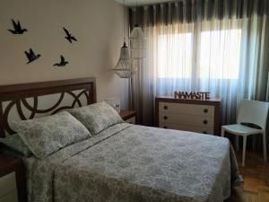 CambreRía del Burgo的卧室配有一张床和墙上鸟儿梳妆台