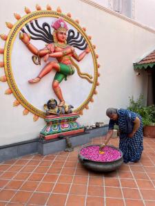 马哈巴利普拉姆Marutham Village Resort的站在女神雕像旁的人