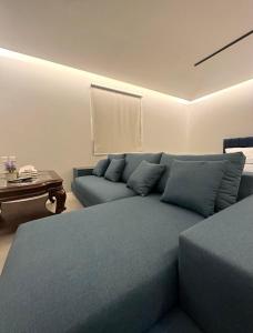 利雅德Villa Apartments的客厅配有蓝色的床和沙发