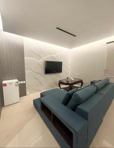 利雅德Villa Apartments的客厅配有蓝色的沙发和电视