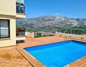 贝尼曼特利Mirador del valle的一座位于庭院内的游泳池,庭院内以群山为背景