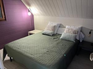 梅尔维尔弗朗瑟维尔普拉格Le chalet Normand的紫色和白色墙壁间的一张床