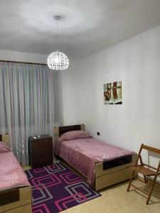 斯库台Dibra Home near City Center of Shkodra的一间卧室配有两张床和吊灯。