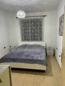 斯库台Dibra Home near City Center of Shkodra的一间卧室配有一张床和一个吊灯