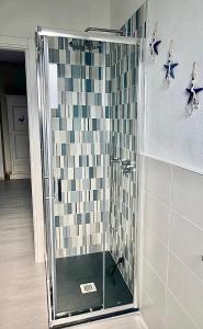 马达莱纳Appartamento Tizzy的一间带淋浴的浴室和瓷砖墙