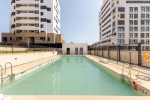 马德里Piso climatizado y parking的一座大型游泳池,其建筑背景为: