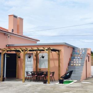 普拉亚达维多利亚O POSTIGO的粉红色的房子,在庭院配有桌椅