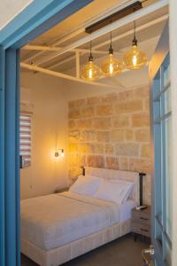 耶路撒冷פרלה צימרים的一间卧室设有一张床和砖墙