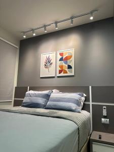 帕尔马斯Apartamento Horizonte Azul, vista lago, próximo ao shopping的卧室配有一张墙上有两张照片的床。