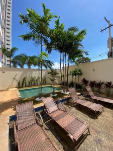 帕尔马斯Apartamento Horizonte Azul, vista lago, próximo ao shopping的一组椅子坐在游泳池旁