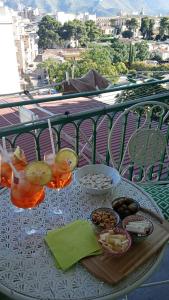 巴勒莫Casa Amari alla Zisa HOSTEL的阳台上的桌子上摆放着饮料和食物