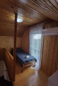 SotinKuća za odmor Bella的一个小房间,设有一张位于带窗户的小屋内的床铺