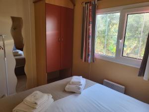 斯代塔维拉Monte da Caldeirinha的卧室配有带2条毛巾的窗户,位于床上