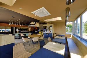 多勒Sure Hotel by Best Western Dole的一间设有蓝色桌椅的餐厅和一间厨房
