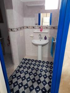 海尔盖莱Maison à Hergla, Sousse, Tunisie的一间带水槽的浴室以及黑白格子地板