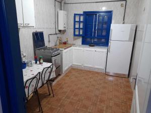 海尔盖莱Maison à Hergla, Sousse, Tunisie的厨房配有白色冰箱和桌椅