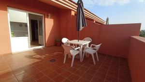 El MatorralVacacional Montañés的庭院配有桌椅和遮阳伞。