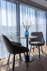 奥本Oban Apartments的窗户客房内的两把椅子和一张桌子