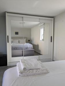 尼亚普拉莫斯Ethos Apartment 2的白色卧室配有镜子和床