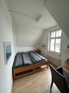 巴塞尔Charmante Altbauwohnung am Rhein的一间卧室配有一张床和一把椅子