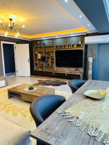 恰纳卡莱Akhome - Luxury dublex apartment的大型客厅配有桌子和电视
