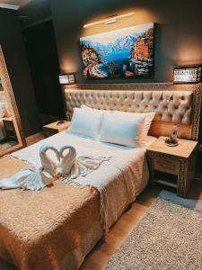 恰纳卡莱Akhome - Luxury dublex apartment的卧室配有一张大床,墙上挂有绘画作品