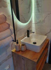 Cienista Dolina的浴室设有白色水槽和镜子