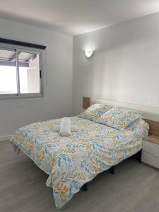 弗龙特拉Las Vistas的一间卧室配有一张带床罩的床和窗户