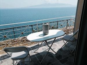 萨兰达Vila SHAKAJ的俯瞰大海的阳台配有一张桌子和两把椅子