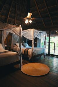 巴卡拉尔Bluebayou Bacalar的配有风扇和地毯的客房内的两张床
