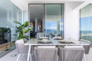 桑蒂亚戈德尔泰德Crystal I Luxury Apartments by EnjoyaHome的一间配备有白色桌椅的用餐室