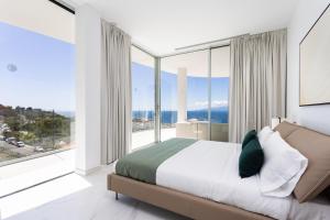 桑蒂亚戈德尔泰德Crystal I Luxury Apartments by EnjoyaHome的一间卧室设有床铺和大型玻璃窗