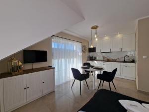 达尔沃沃Apartamenty Malaga II的厨房以及带桌椅的用餐室。
